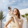 foldable-turbo-handheld-fan-for-ice-cool-relief Happy woman holding a silver portable ice-cool relief fan with a power bank feature.